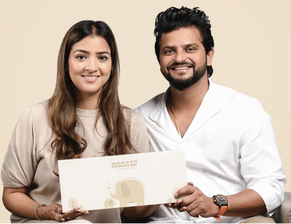 Priyanka and Suresh Raina seated side by side, smiling and jointly holding Maate’s signature ivory gift box. 